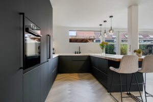 Zwarte keuken op maat met beige stoelen