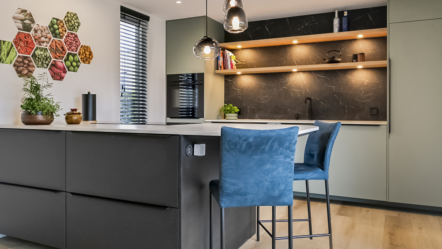 Groene keuken met donkere keuken eiland.